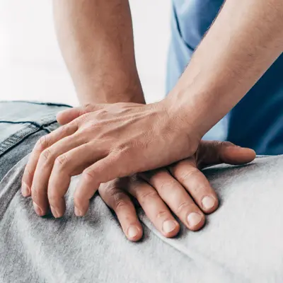 Chiropractor applying hands-on pressure to a patient's lower back
