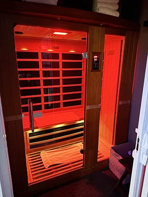 Infrared sauna glowing with red light inside a private therapy room