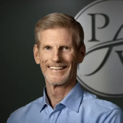 Portrait of chiropractor Kory Branham smiling in a blue collared shirt